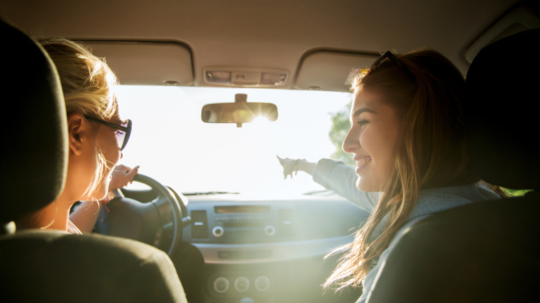 Two teenage girls driving into sunlight